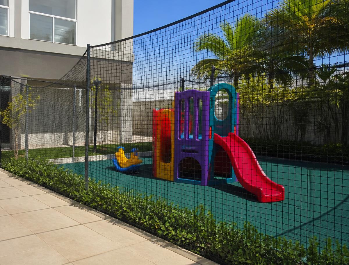 Playground de condomínio cercado por tela de proteção